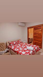 Schlafzimmer mit einem Bett mit einer roten und weißen Decke in der Unterkunft WESTWOOD - DELUXE 03 BEDROOM APPARTMENT - POOL, near BEACH in Flic-en-Flac