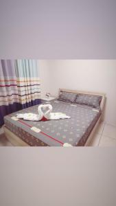 Una cama con dos toallas blancas encima. en WESTWOOD - DELUXE 03 BEDROOM APPARTMENT - POOL, near BEACH, en Flic en Flac