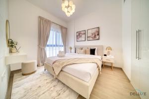 a white bedroom with a large bed and a window at Serene 2BR at The Nook Wasl Gate Jebel Ali by Deluxe Holiday Homes in Dubai
