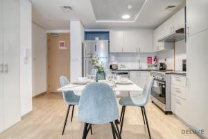 a kitchen with a white table and chairs at Serene 2BR at The Nook Wasl Gate Jebel Ali by Deluxe Holiday Homes in Dubai