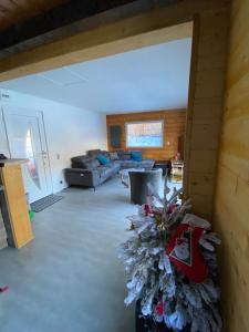 a living room with a couch and a christmas tree at Chalet paisible 6 personnes in Uvernet