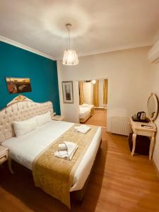 イスタンブールにあるAdora Hotel Cafe & Restaurantの青い壁のベッドルーム1室(大型ベッド1台付)