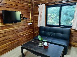 sala de estar con sofá y mesa en สายฝนการ์เด้น, en Ban On Luai