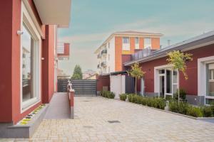 a woman walking down a street between two buildings at Terranova49 in Novara