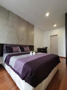 - une chambre avec un grand lit et une couverture violette dans l'établissement LAVENDER Suite @ I-City, à Shah Alam