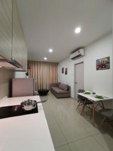 Il dispose d'une cuisine et d'un salon avec un canapé et une table. dans l'établissement LAVENDER Suite @ I-City, à Shah Alam