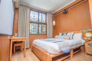 Postel nebo postele na pokoji v ubytování Nanjing Tulou Xinyuan HomeStay