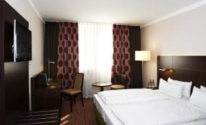 a hotel room with a bed and a table and a window at Stern Hotel Soller in Ismaning