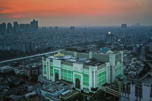 un gran edificio en una ciudad al atardecer en Yellow Bee Tanah Abang en Yakarta