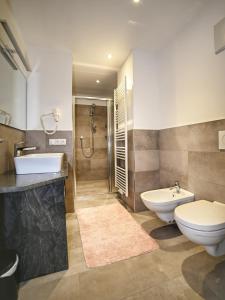 een badkamer met een toilet, een wastafel en een douche bij Ferienwohnung im Herzen der Dolomiten in Carezza al Lago