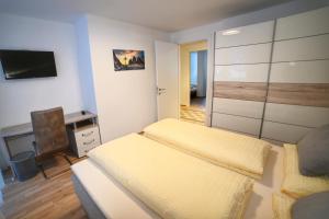 a bedroom with a bed and a desk and a tv at Ferienwohnung im Herzen der Dolomiten in Carezza al Lago