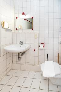Un baño blanco con lavabo e inodoro. en Ferienwohnung in ruhiger Stadtlage, en Würzburg
