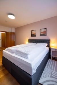 1 cama blanca grande en un dormitorio con 2 cuadros en la pared en Ferienwohnung in ruhiger Stadtlage, en Würzburg 27 fotos más