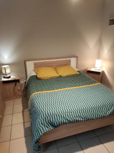 1 dormitorio con 1 cama con 2 lámparas en las mesas en La ferme du Grand Faubourg, en Pont-de-Vaux