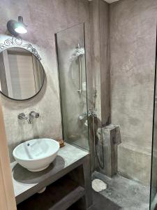 a bathroom with a sink and a shower with a mirror at Kamares View in Kavála
