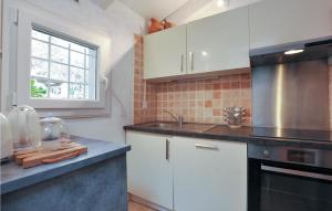 a kitchen with white cabinets and a sink and a window at Beautiful Apartment In La Gaude With Kitchenette in La Gaude