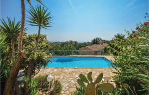 uma piscina num jardim com palmeiras em Beautiful Apartment In La Gaude With Kitchenette em La Gaude
