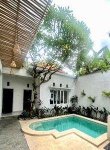 een zwembad op de binnenplaats van een huis bij Best Canggu Hostel in Canggu