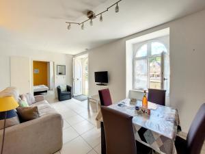 a living room with a table and a couch at Au Fil De L'Eau - Le Bord de Rance in Dinan