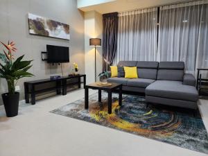 sala de estar con sofá y mesa en Avenpeak Homestay Tamarind Wifi, Netflix, Iron, Filter, TV, Self Checkin, en Cyberjaya
