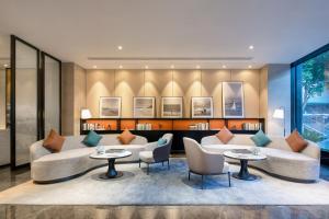 a living room with a couch and chairs and tables at Xin'an Yihao Hotel - Near Xiamen Railway Station, near Vientiane City, minibar is free in Xiamen
