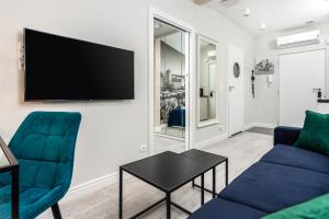 salon z kanapą i telewizorem na ścianie w obiekcie Ariańska apartment - Cracow, city centre w Krakowie