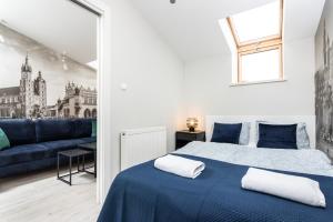 sypialnia z niebieskim łóżkiem i niebieską kanapą w obiekcie Ariańska apartment - Cracow, city centre w Krakowie