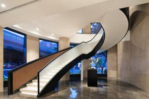 a spiral staircase in a building with windows at Xin'an Yihao Hotel - Near Xiamen Railway Station, near Vientiane City, minibar is free in Xiamen