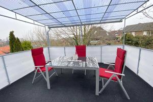 - une table et deux chaises rouges sur la terrasse dans l'établissement Work & Stay in Kleve, à Clèves