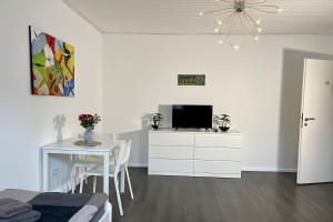 - un salon blanc avec une table et une télévision dans l'établissement Work & Stay in Kleve, à Clèves