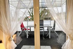 - une table et des chaises dans une chambre avec rideaux dans l'établissement Work & Stay in Kleve, à Clèves