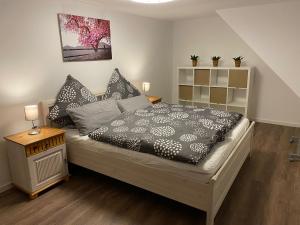 a bedroom with a bed with a black and white comforter at Ferienhaus Am Riedbach - Birstein in Birstein