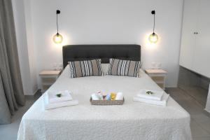 a white bed with two towels and a basket on it at Karinta Bay Apartments in Chios