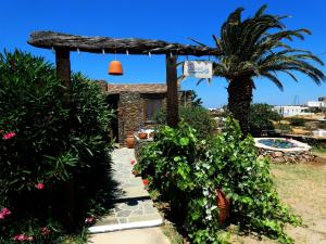 einen Garten mit einer Pergola und einer Palme in der Unterkunft Το Κατἑ in Artemonas