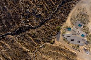 an aerial view of a house in a field at Homa Serifos pool villas in Serifos Chora