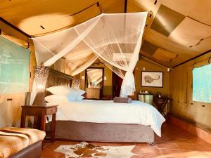 En eller flere senge i et værelse på Nyala Luxury Safari Tents