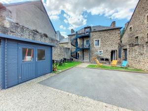 um edifício com uma garagem azul em frente em Au Fil De L'Eau - Le Bord de Rance em Dinan