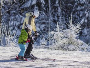 a man and a child on skis in the snow at Landal Marina Lipno in Lipno nad Vltavou