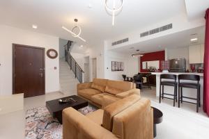 uma sala de estar com um sofá e uma mesa em Stunning 3 bedroom townhouse in Townsquare em Dubai