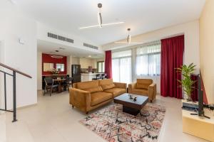 uma sala de estar com um sofá e uma mesa em Stunning 3 bedroom townhouse in Townsquare em Dubai