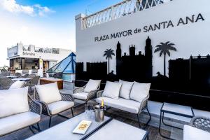 a group of chairs and tables on a patio at Boutique Hotel Cordial Plaza Mayor de Santa Ana in Las Palmas de Gran Canaria