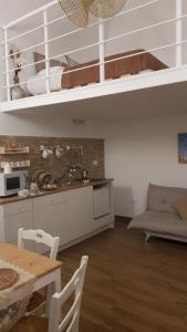 a kitchen with white cabinets and a table with chairs at ARAGONESE 73 in Taranto