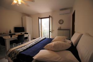 1 dormitorio con cama, escritorio y ventana en Casa Vacanze Doralice, en Barzana