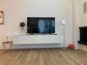 una sala de estar con TV en un centro de entretenimiento blanco en Holidayhouse4You en Schwanau