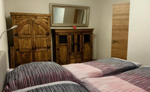 a bedroom with a bed and a dresser and a mirror at Holidayhouse4You in Schwanau