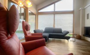 a living room with a couch and a chair and a tv at Holidayhouse4You in Schwanau