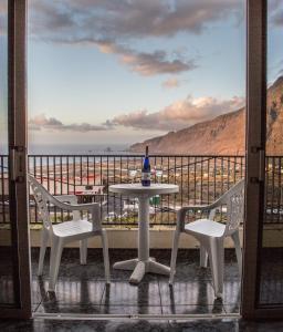 una mesa y sillas en un balcón con vistas al océano en Apartamentos Jucar, en La Frontera