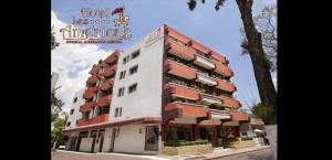 un edificio blanco alto con techos rojos en Hotel Las Américas en Morelia