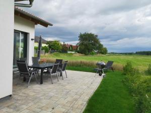 a patio with a table and chairs and a grill at Holidayhouse4You in Schwanau