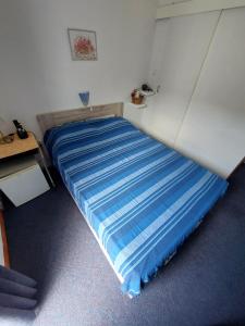 un letto in una piccola camera con lenzuolo blu di Villa Vilma a Sukošan (San Cassiano)